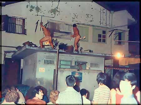  Dance of the Flaming Arseholes - Bugis Street in the 60s was made up of two streets that resembled a T-junction. In the middle of the junction was a toilet block.  The place stank to high heaven. When you used the urinals it went straight out onto the floor. You had no choice but to walk in the urine. The stench of ammonia was unbelievable.  If you wanted a crap, well that was even worse. You would have to put up one hand against the door to stop any Kai Tai's fom coming in while the other hand was over your nose to stop the smell of the crap already filling the bowl. If you were smart you had your own paper, if not, well . . . !  The roof of the toilet block was a favourite place for Aussie and Kiwi sailors to perform their ritual  'Dance of the Flaming Arseholes'. 